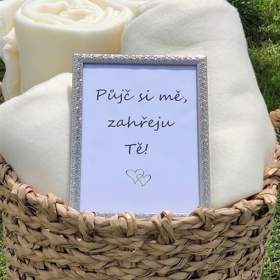 Proutěný koš s bílými dekami a cedulkou